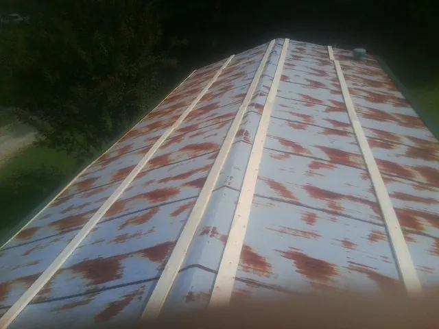 Rusted metal roof panels with new wood purlins before replacement — Storm Damage Roof Repair in Forestville by Roofing Brothers